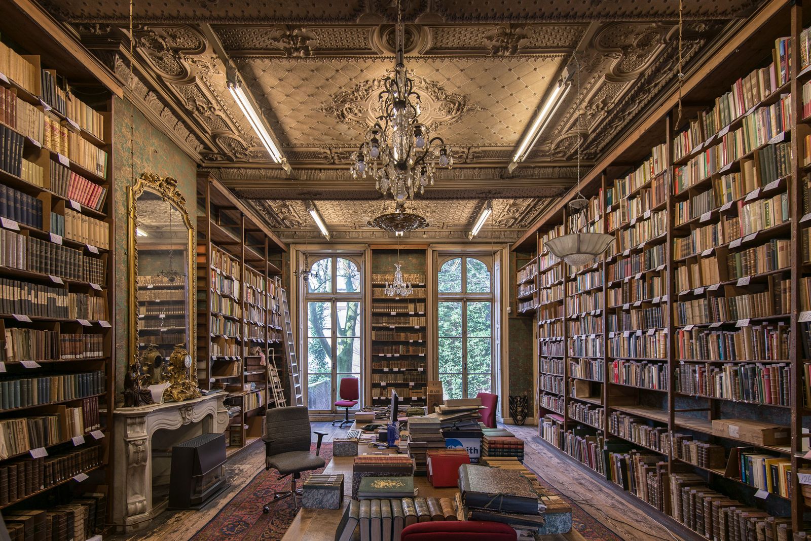 bibliotheek met boekenkasten en kroonluchter in een herenhuis in Den Haag