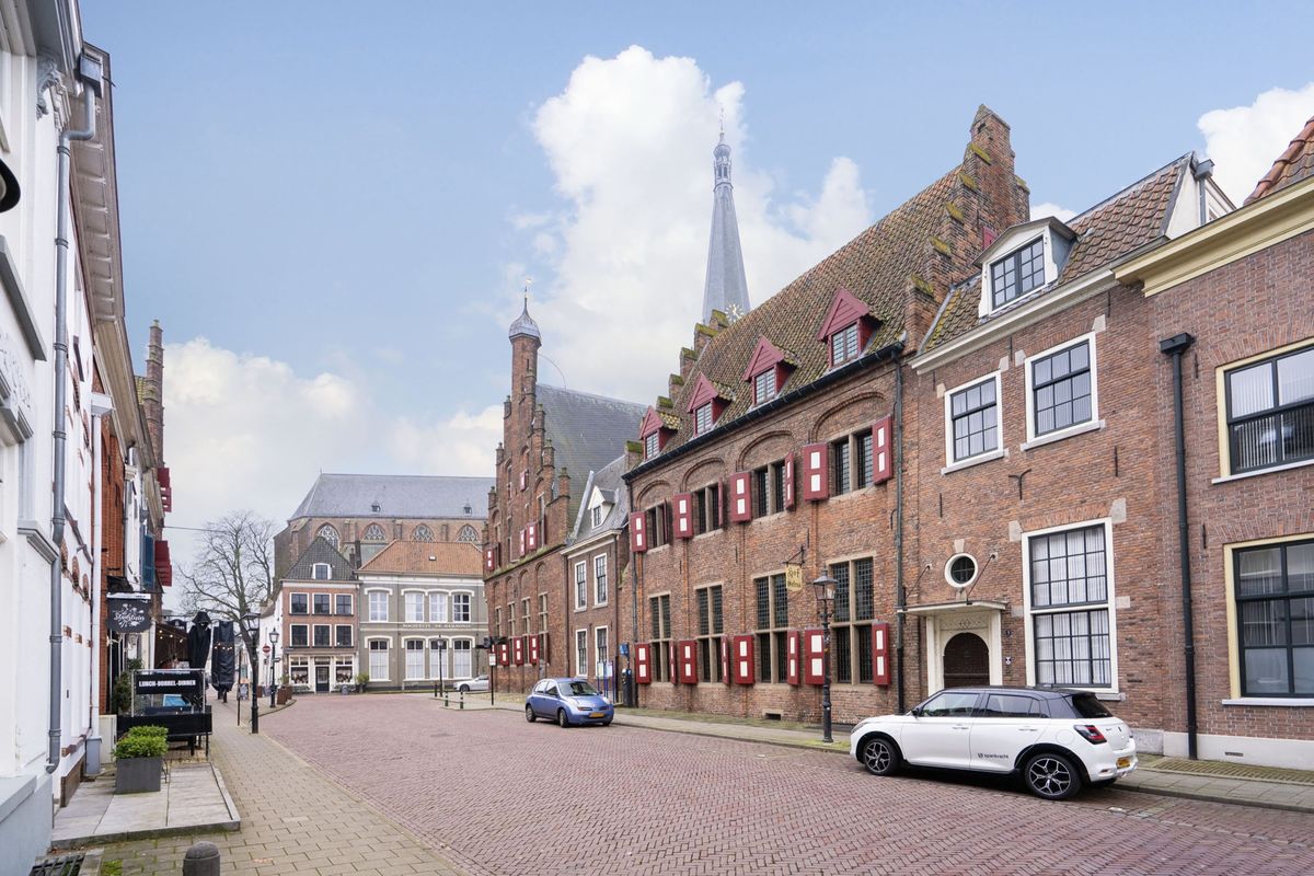 het raadhuis van Doesburg met een rode baksteengevel en een kerktoren op de achtergrond
