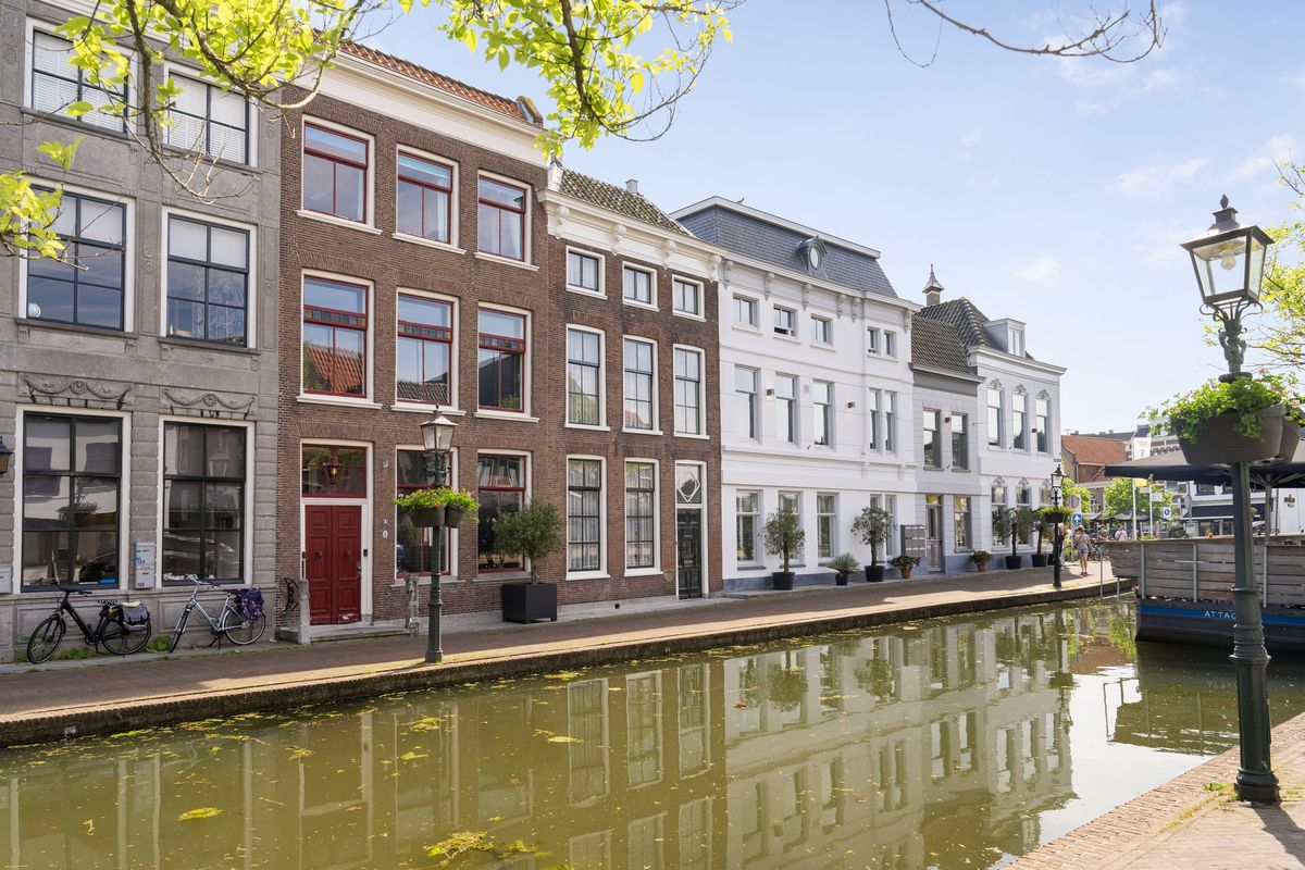 gracht met een gevelrij langs het water in Maassluis, met een oude lantaarn op de voorgrond
