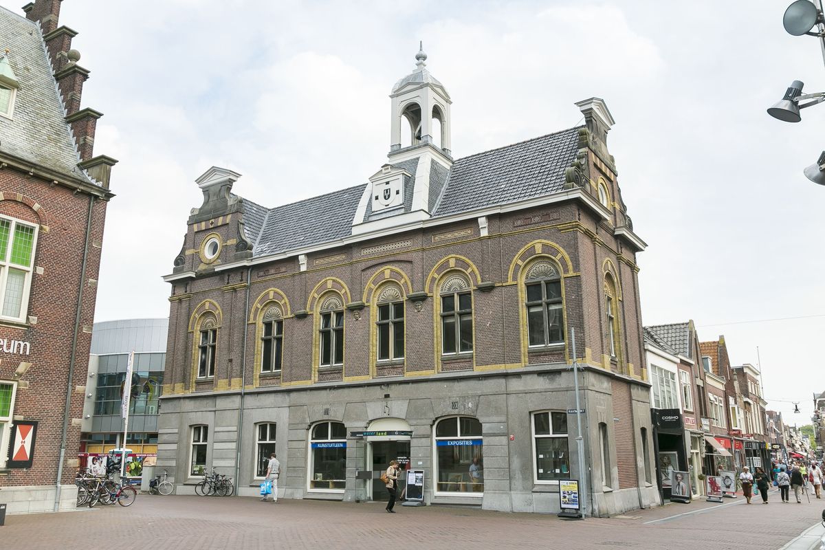 bakstenen gebouw met natuurstenen banden, hoge vensters en een dakruiter aan de Kaasmarkt in Purmerend
