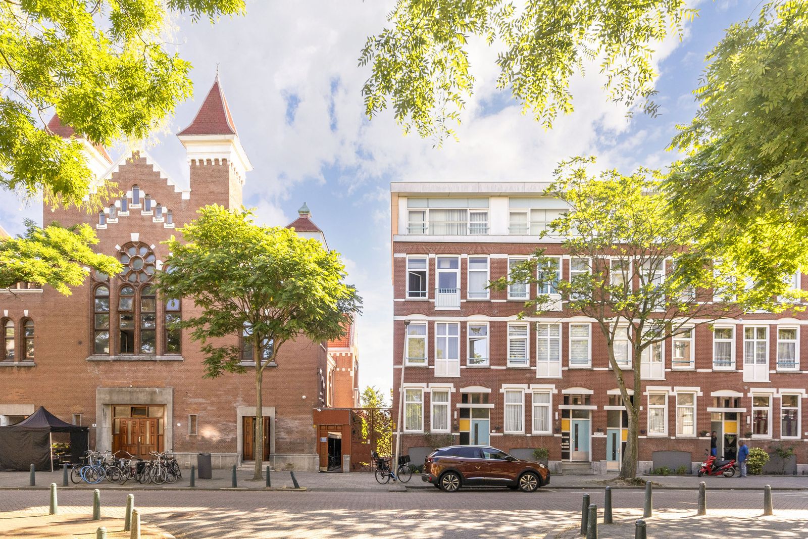 straatbeeld in Rotterdam met een kerkgebouw en een woonblok in bakstenen