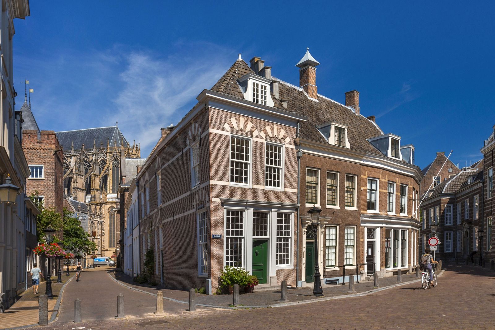 smalle straat met bakstenen huizen en trapgevels en een kerk op de achtergrond in Utrecht