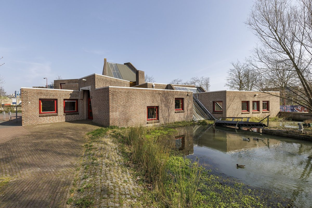 laag bakstenen kerkgebouw met een toren achter een gracht in Nieuwegein