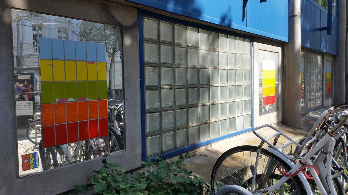 gevel van het Hubertushuis met gekleurde tegelvlakken en glasblokken